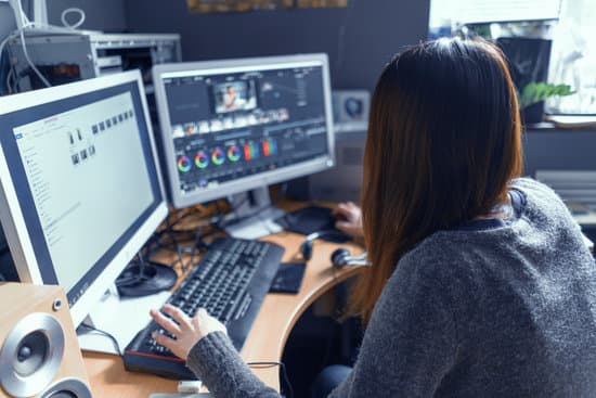 woman processing video on multiple computer monitors