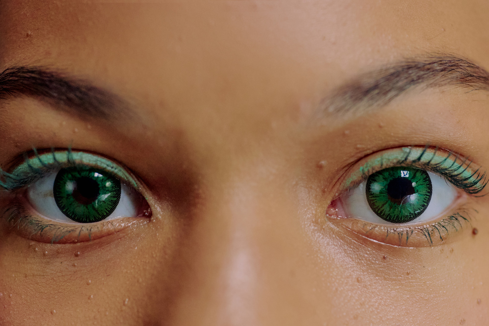 Close-up of woman with green contact lenses