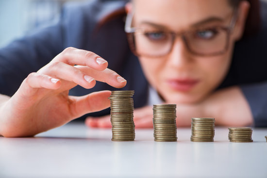 woman in glasses counting stacks of coins