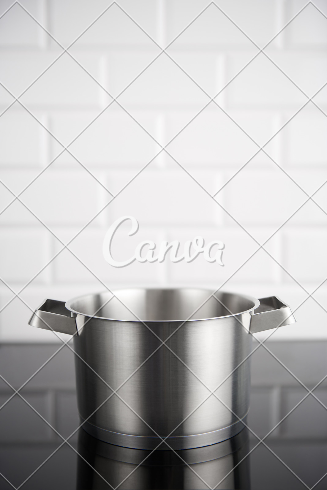 Stainless Steel Pot On The Induction Stove With White Metro Tile