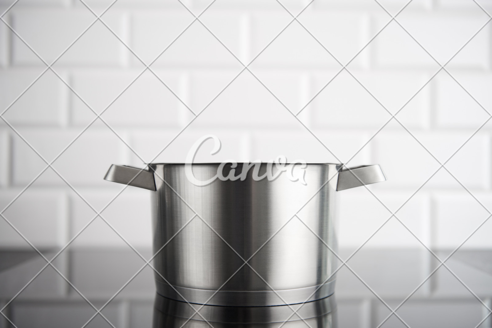 Stainless Steel Pot On The Induction Stove With White Metro Tile