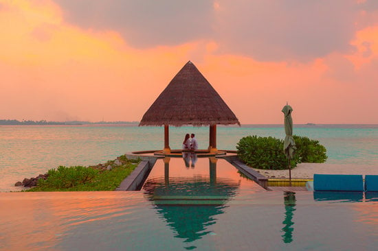 Couple Under Hut Beside Sea and Infinity Pool