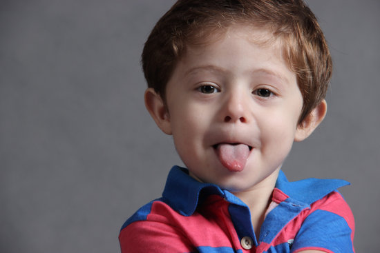 Child Wearing Blue and Red Stripes Polo Shirt Sticking Out Tongue