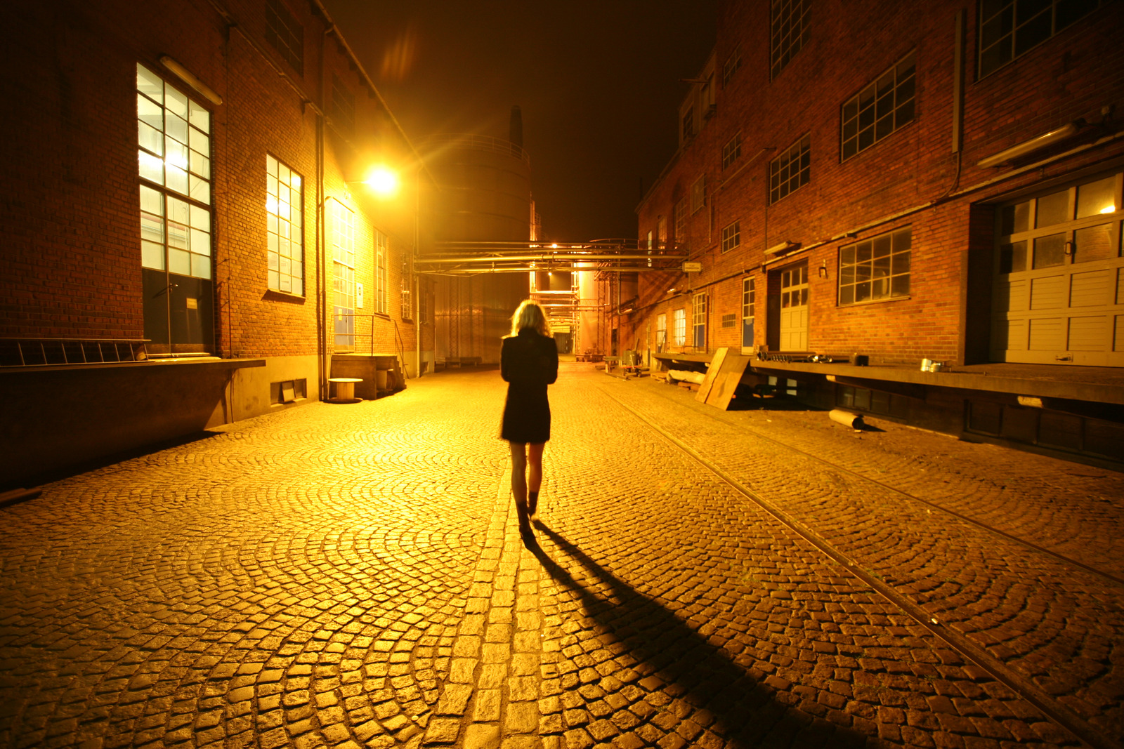 Back View of a Woman Walking on Street at Night