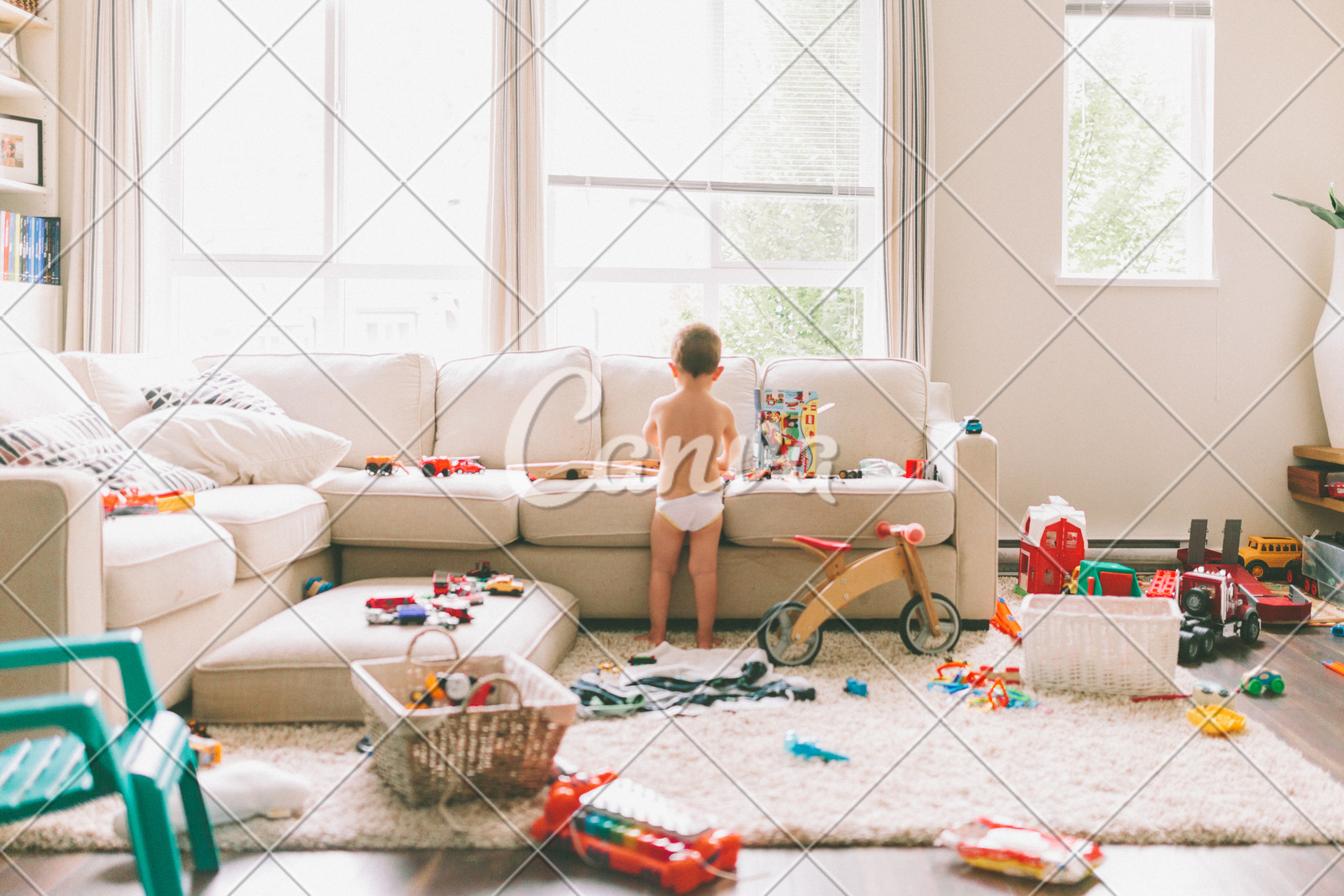 Messy House With Toddler Playing Toys In The Living Room