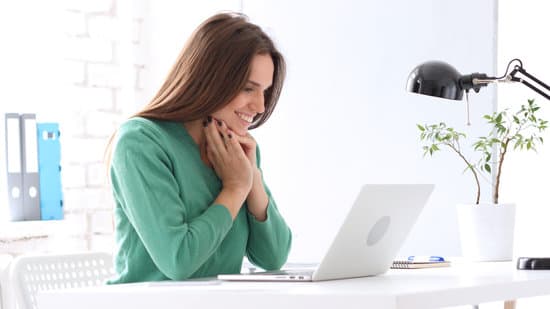 Happy Woman Looking at Laptop and Smiling, Impressed