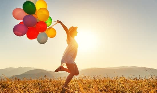 happy woman with balloons at sunset in summer