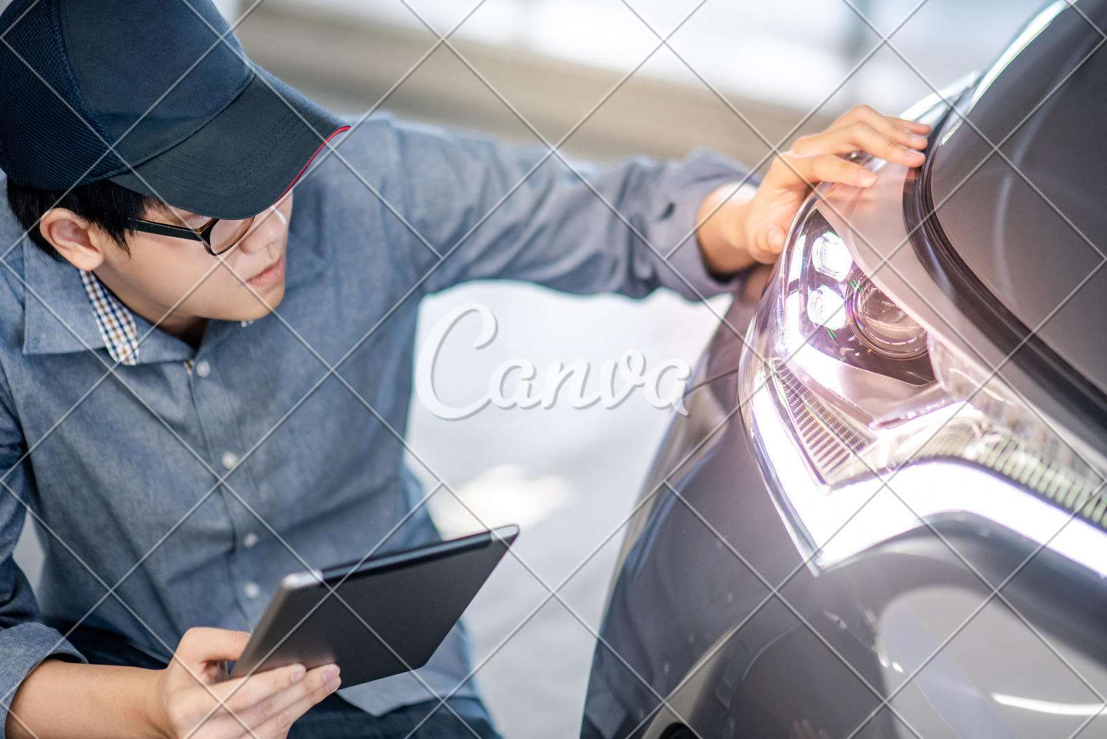 Young Asian Auto Mechanic Holding Digital Tablet Checking