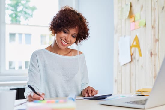 Happy woman working at home calculating finances